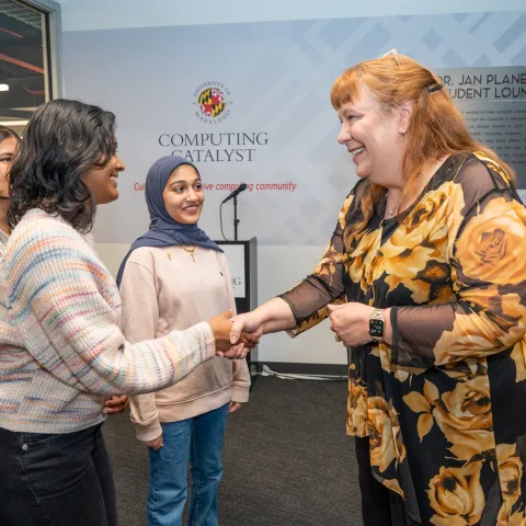 Dr. Jan Plane shaking hands with students in the newly named Dr. Jan Plane Student Lounge