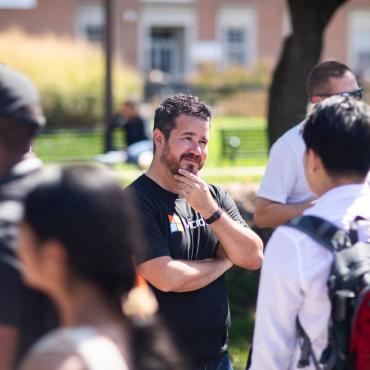 Man wearing a Microsoft T-shirt speaking with students at Tech Block Party
