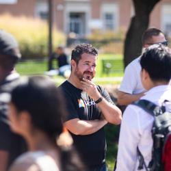 Man wearing a Microsoft T-shirt speaking with students at Tech Block Party