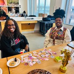 Two students sitting at a table and smiling at the camera