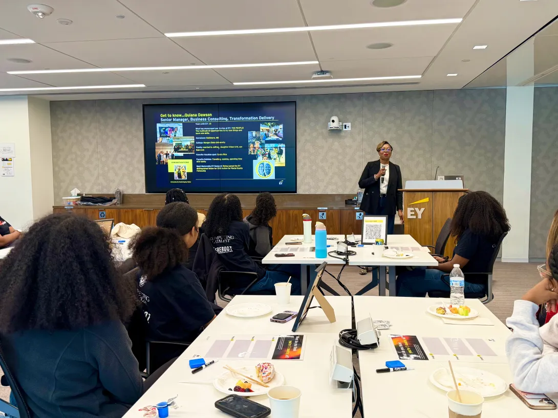 EY's Quiana Dawson stands at the front of a room and presents to RESET Scholars