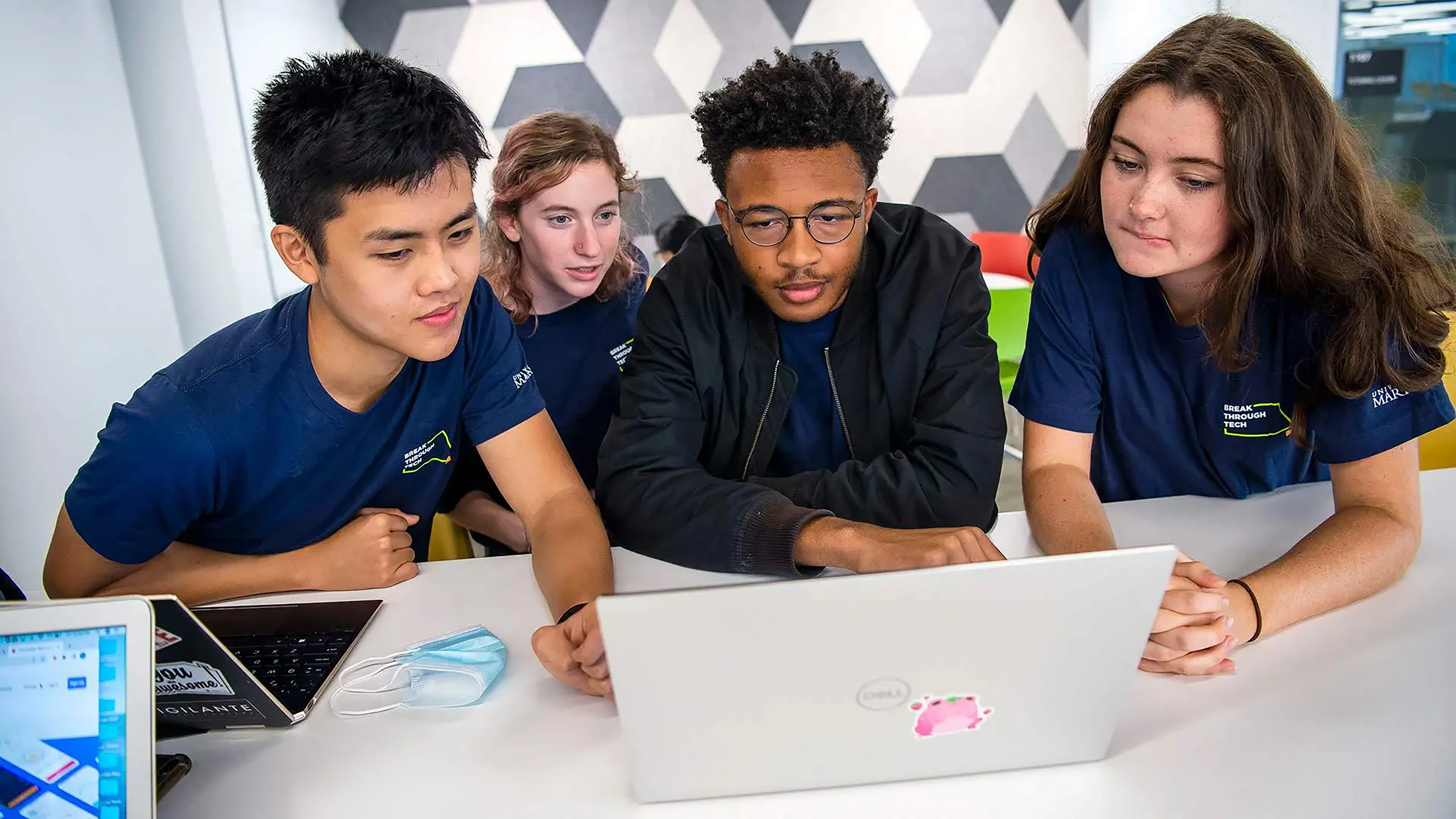 Students gathered around laptop at Guild 2022